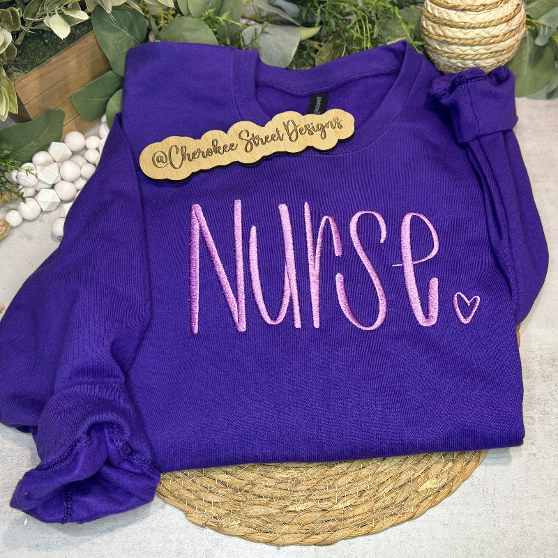 Purple sweatshirt with 'Nurse' text 