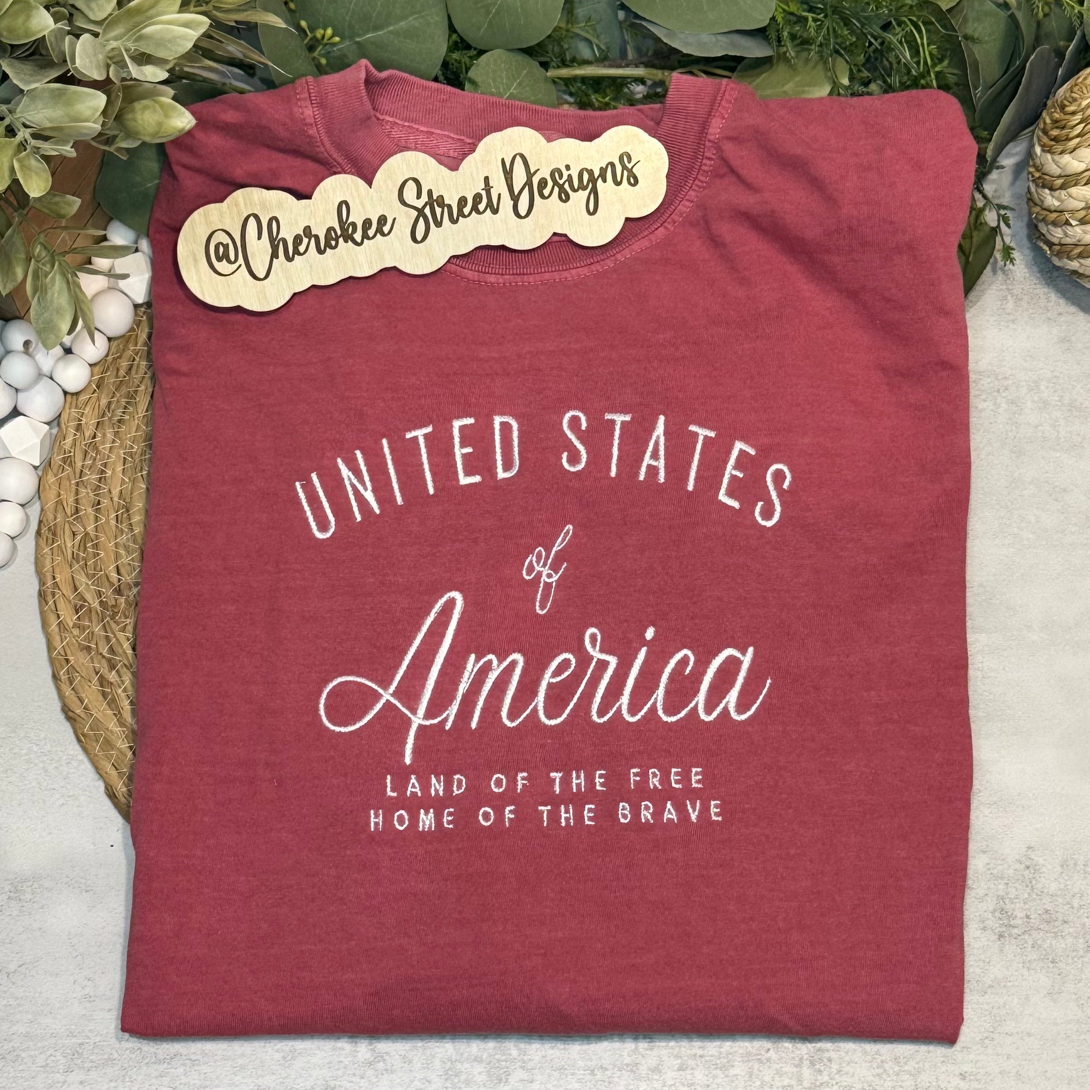 Maroon t-shirt with 'United States of America' text on a light background