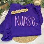 Purple sweatshirt with 'Nurse' text 