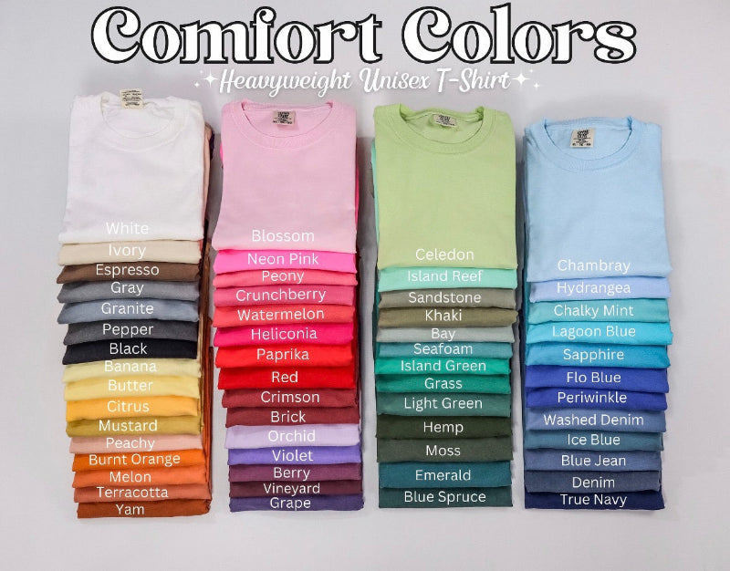 Stacks of colorful t-shirts with labels on a gray background, featuring the 'Comfort Colors' brand.