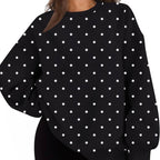 A woman wearing a black long-sleeve sweatshirt with a white polka dot pattern, paired with black bike shorts, shown against a plain white background.