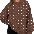 A woman wearing an oversized brown sweatshirt with a white polka dot pattern, paired with black shorts, shown against a plain white background.