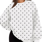 A woman wearing a white long-sleeve sweatshirt with a black polka dot pattern, paired with black shorts, shown against a plain white background.