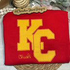 Red sweatshirt with yellow 'KC' logo 