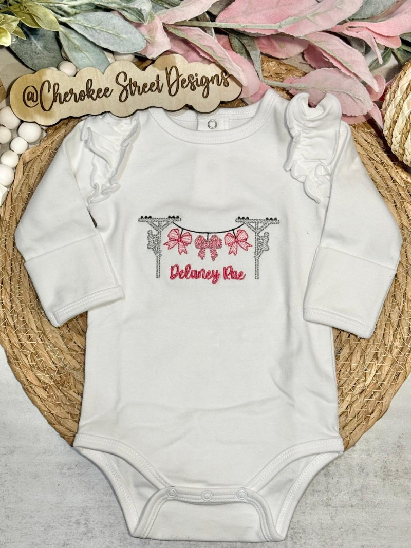 White baby onesie with decorative design and text 