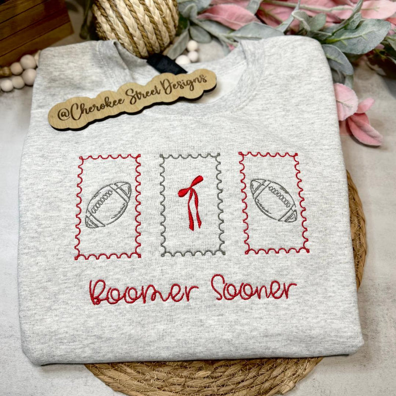  gray sweatshirt with embroidered designs and text 