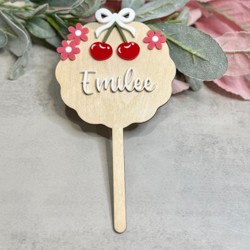 Wooden name tag with a stick, decorated with flowers and cherries