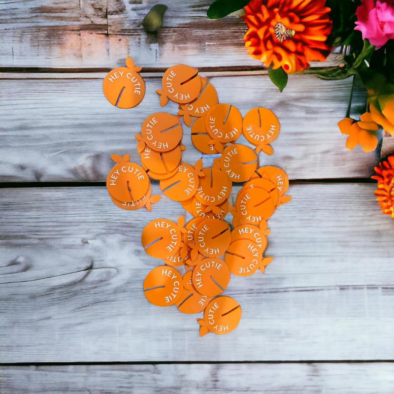 Orange heart-shaped tokens with 'HEY CUTIE' text 