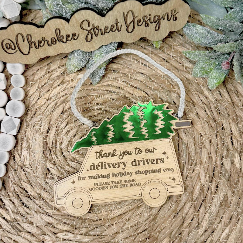 Decorative ornament with a truck and Christmas tree design, featuring text