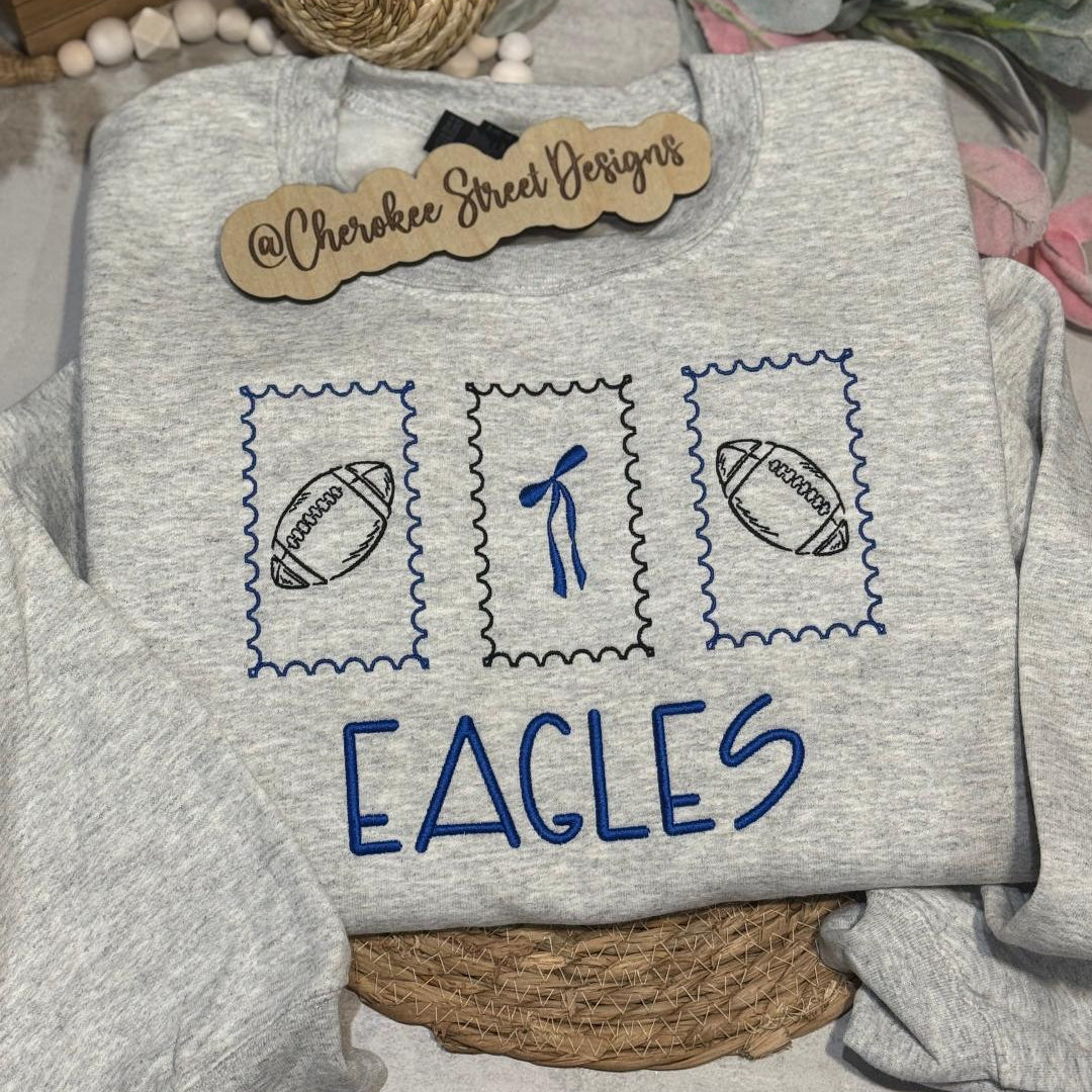 Gray sweatshirt with 'EAGLES' text and sports-themed designs