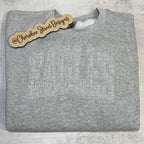 Folded gray sweatshirt with 'EAGLES' text 