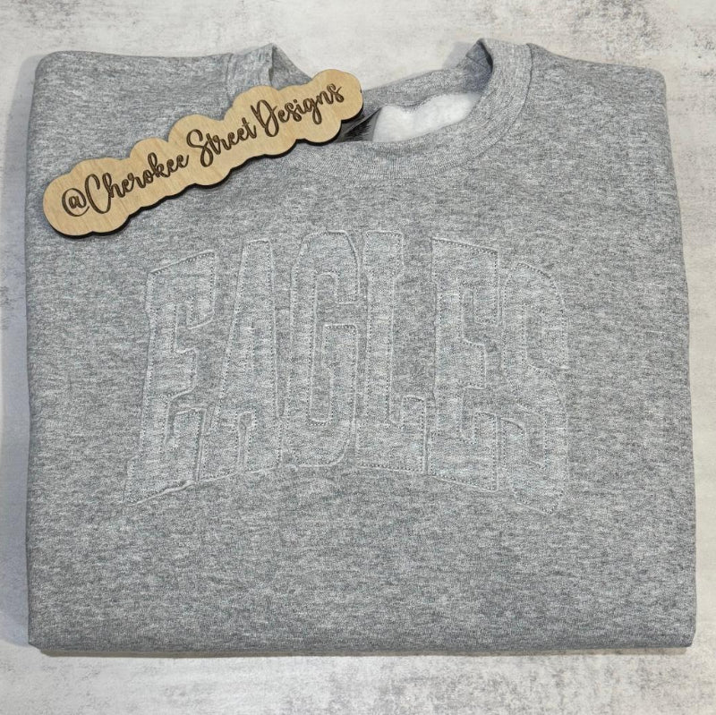 Folded gray sweatshirt with 'EAGLES' text 