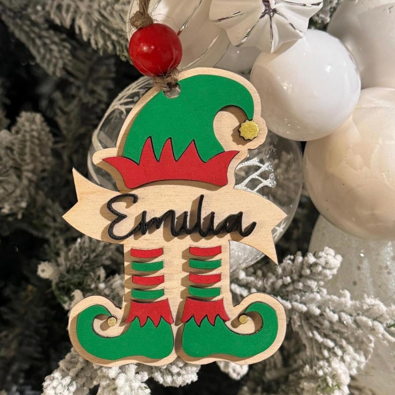 Elf-themed wooden ornament with 'Emilia' on a Christmas tree.