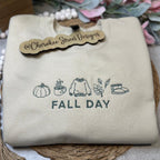 Beige sweatshirt with 'Fall Day' text and icons 
