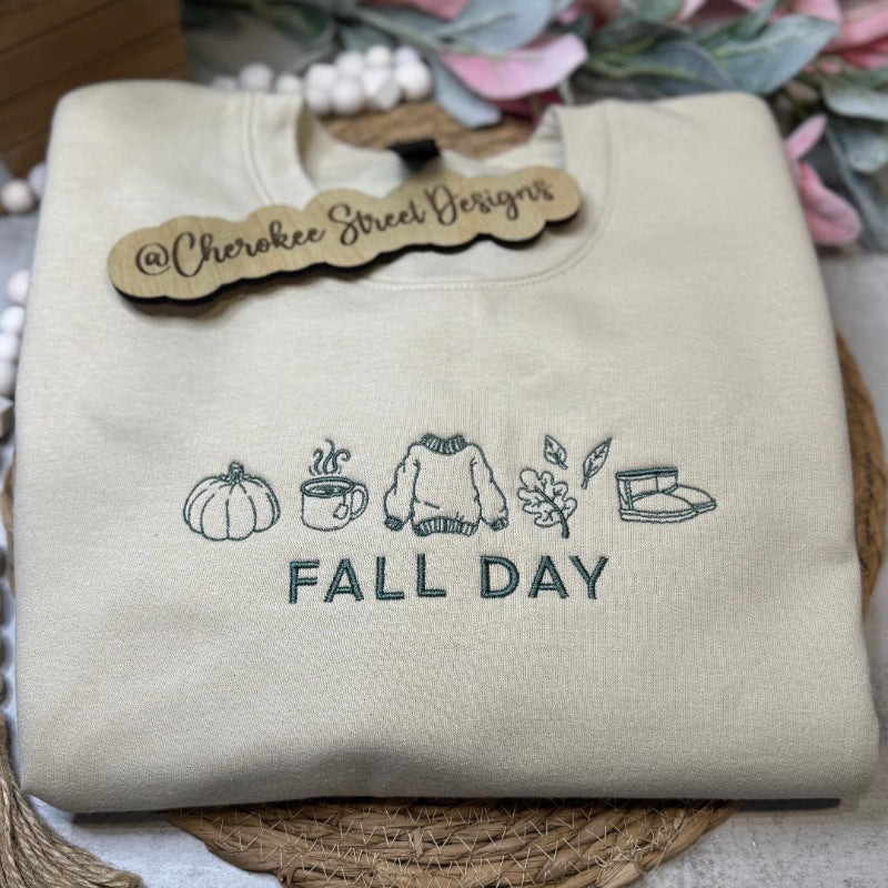 Beige sweatshirt with 'Fall Day' text and icons 