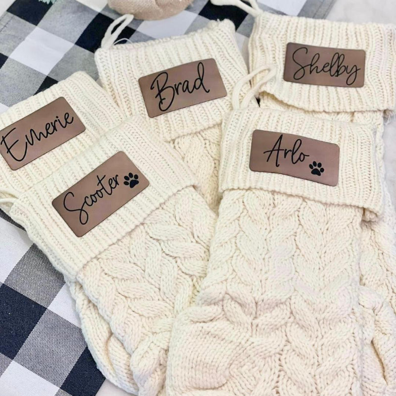 Cream-colored cable knit stockings  with name labels
