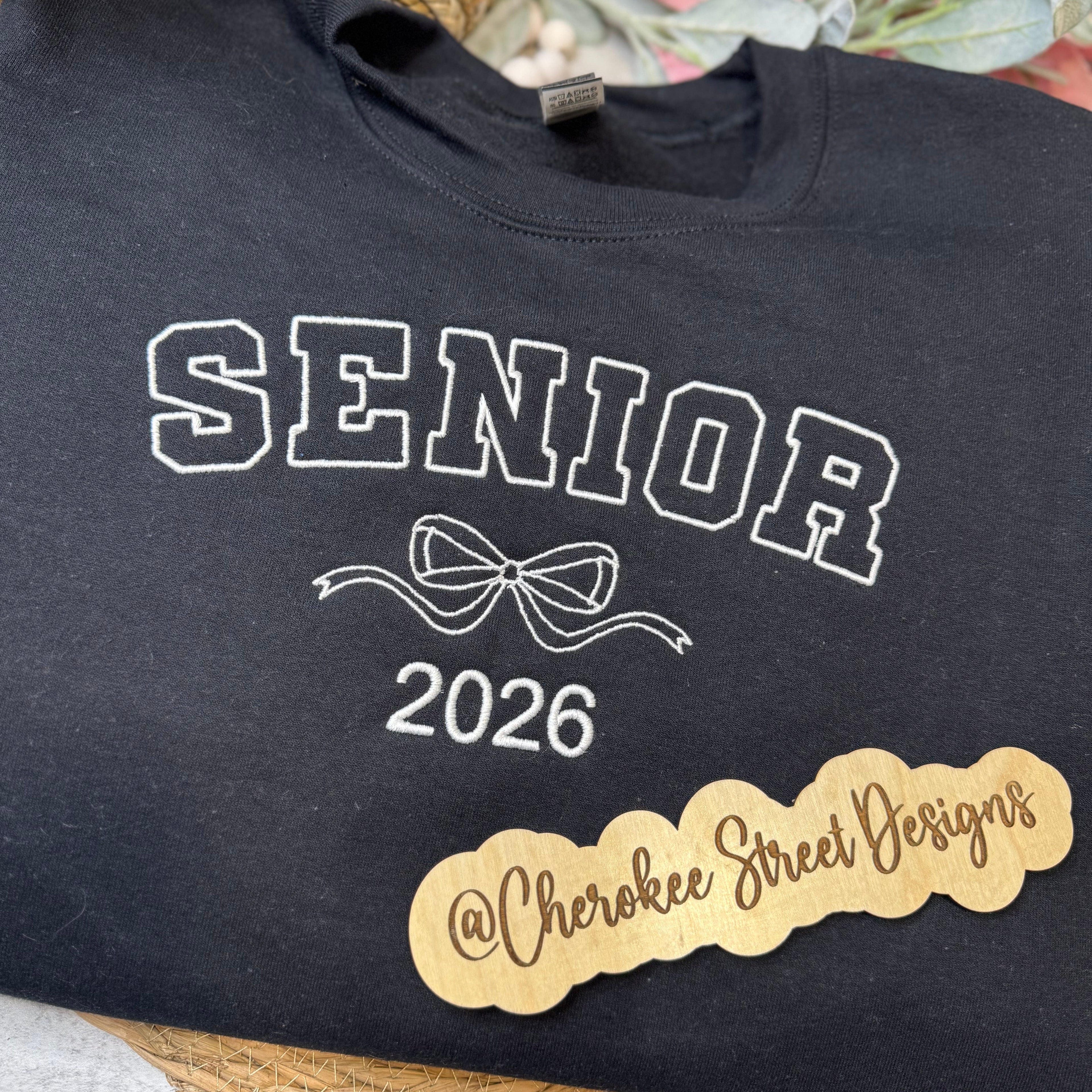 Black sweatshirt with 'Senior 2026' text and a bow design