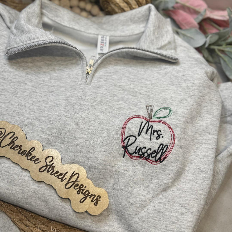 Gray pullover with embroidered design and 'Mrs. Russell' text