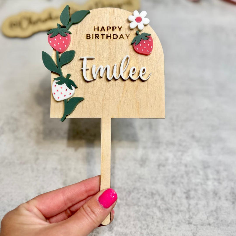 Wooden birthday cake topper with decorative elements and 'Happy Birthday text,