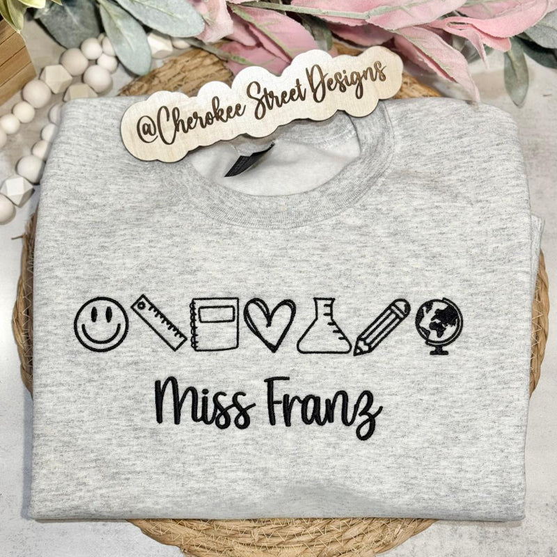 Gray sweatshirt with icons and text 'Miss Franz' 