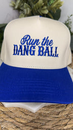 A two-tone baseball cap with an off-white crown and a royal blue brim. The front of the cap features blue embroidered text reading 'Run the DANG BALL'.