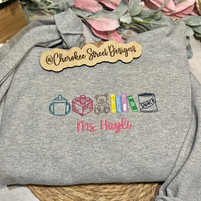 Gray sweatshirt with embroidered designs and text